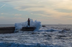 Foz Lighthouse during a storm at sunset in Atlantic ocean, Porto, Portugal.