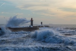 Foz Lighthouse during a storm at sunset in Atlantic ocean, Porto, Portugal.
