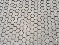 The texture of the paving slabs of the street in a round shape of gray color for design