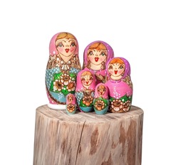 Babushka dolls arranged on wood log. Group of colorful painted Russian stacking dolls also known as Matroska doll or Russian tea dolls. Symbole of grandmother or fertility. Isolated on white.