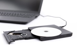 closeup of an open external DVD player attached to a black notebook computer isolated on white