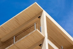 Close view of the vertical supports and interior ceiling of a engineered timber multi story green, sustainable residential high rise apartment building construction projec