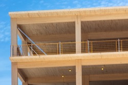 Looking up at the vertical supports, and interior ceiling of a engineered timber multi story green, sustainable residential high rise apartment building construction project