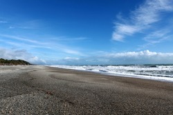 stone beach in newzealand at pacific with blue sky background