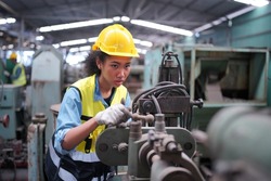 Factory Female Industrial Engineer Works in metal working factory, Inside the Heavy Industry. Portrait of working female industry technical worker or engineer woman working in an industrial.