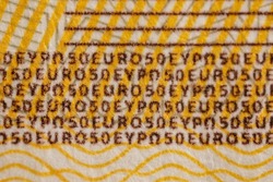 Detail of a real 50 euro banknote, close-up with small textured text, lines and swirl details. European currency money. Inflation, business, economics and finance theme
