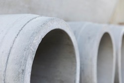 Concrete drainage pipes for wells and water discharges. Building material used for construction close-up. Due to the making process concrete is an unsustainable and not eco-friendly resource