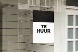 Sign 'Te huur' meaning 'For rent' on a window of an empy store facade placard. Retail shopping business exterior after closing down sale in The Netherlands, Europe