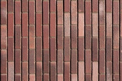 Dark brown redish bricks used in new modern architecture, the wall of an exterior residential home. Chique stylish trend in darker stone tiles and bricks creating a luxury feeling, horizontal