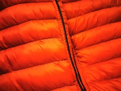 puffer jacket closeup in vivid bright red fabric material with black zip