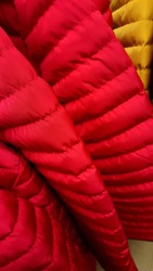 closeup of vivid red and yellow puffer jacket quilted material