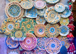 Various decorated pottery dishes hung for sale outside a souvenir shop in Erice, Sicily