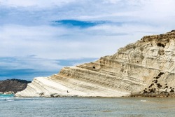 A woman alone on the Scala dei Turchi or Stair of the Turks or Turkish Steps, rocky cliff formed by marl, on the coast of Realmonte in Sicily, Italy