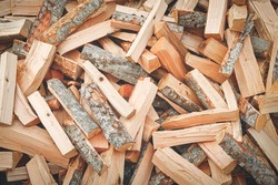 Logs, natural wood texture background. Pile of chopped firewood tree logs at lumber mill. Preparation for winter time. Fireplace or stove material. Timber industry concept. Close up, selective focus