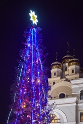The view of  illuminated new year tree on the background of St. Nicholas church (Cultural and educational center Tsarsky) at night. Yekaterinburg. Russia