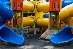 Bright colored playground with slides and pipes on a city street
