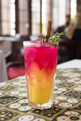 Coconut Island is a drink that is a mixture of orange-flavored syrup and coconut-flavored flavors that don't blend before being stirred. garnished with cinnamon and mint leaves
