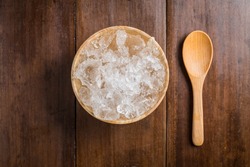 wooden Bowl with ice Cubes on wood table background