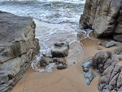 Waves through the rocks and wet sand
