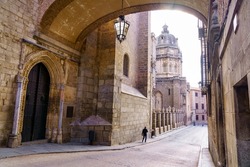 Toledo Cathedral under the stone arch of an old building in the city of Toledo Spain.