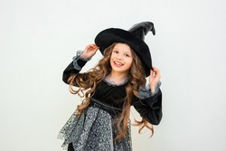 A cheerful witch on a white isolated background. A child at a Halloween party. A child in a magical costume. children's magic in action.
