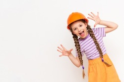 A little girl in a construction helmet spread her fingers like a fan.  The concept of renovation in a children's room on a white isolated background.