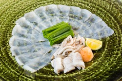 Fugu sashimi and fugu's entrails are in the green plate