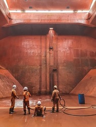 ship crews are performing cargo hold cleaning on a bulk carrier. preparing for loading cargo.