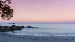 Heavenly peaceful beach in pastel color morning light good for mentally health. The sand beach and calm sea in pastel sunrise morning with a bright star in the sky. No people during pandemic covid19.