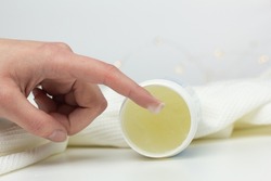 Closeup of a person applying petroleum jelly to their hand.