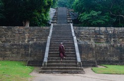 A Sri Lankan Buddhist Monk Climbling the stairways on the way to Yapahuwa Rock fortress located between Kurunegala and Dambadeniya