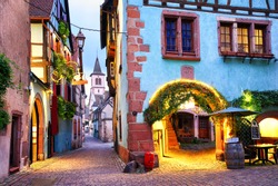 Picturesque street with traditional colorful houses in Riquewihr village on alsatian wine route, Alsace, France