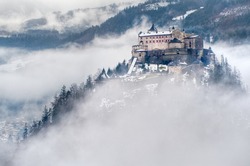 Castle Hohenwerfen by Salzburg high over clouds on a misty mountain in the Alps