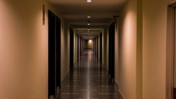 long hallway with doors and warm light