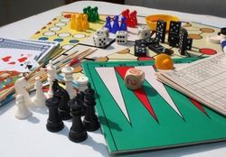 Set of table games with white and black chess pieces in the foreground 