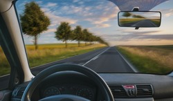 A view from the cockpit of a car driving on a country road