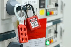 Red key lock and white tag for process cut off electrical on control panel in substation at chemical plants, power plants, oil & gas industry or onshore industry. isolation tag and do not remove tag.