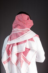 Saudi Arabian man wears traditional Saudi Clothes (Shmag). Photograph portrait from behind.