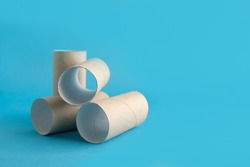 Empty rolls of toilet paper sleeve lie on a blue background. Place for text. Panic with lack of toilet paper.