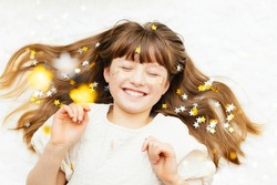 Portrait of a pretty girl with star-shaped sequins on her face. The girl smiles. Fun holiday, party or carnival for kids. Children's happiness