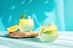 Summer detox refreshing drink or alcoholic cocktail with lemon slices and ice, garnished with a sprig of mint. Chilled water with lemon. Healthy drinks