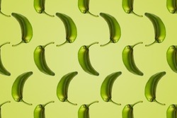 Pattern of green peppers isolated on light green background. Creative photo of peppers aligned with copy space.