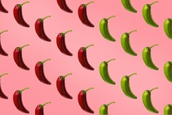Pattern of red and green peppers isolated on pink background. Creative photo of peppers aligned with copy space.