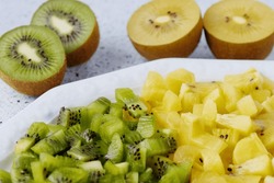 Kiwifruit of different types colors: green kiwi fruit and golden yellow kiwi. Salad cut in bowls.