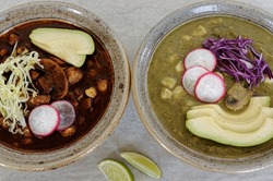 Vegan Pozole Verde and vegan Pozole Rojo with toppings. Mexican dishes with hominy (cacahuazintle), shredded jackfruit and button mushrooms.
