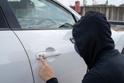 A man checking the keyhole of a car.