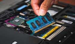 Laptop repair engineer (PC computer) and motherboard install random access memory (ram memory) in computer lab top.