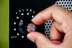Hand adjusting volume control.Use hand to adjust the volume at the volume control button of the amplifier.