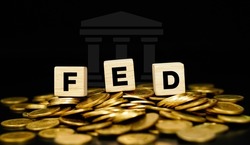 The Federal Reserve (FED) concept to control interest rates. World economy crisis gold coin background. Business concept.