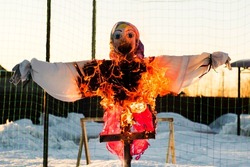 Scarecrow of a woman is on fire. The effigy at the Shrovetide festival is burning.